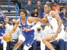  ?? BILLINGS/AP NATE ?? Sixers guard Tyrese Maxey, left, drives to the basket against Thunder guard Shai Gilgeous-Alexander, right, in the first half of Sunday’s game in Oklahoma City.