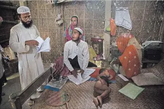  ?? ANUPAM NATH THE ASSOCIATED PRESS ?? Muslim farmer Abdul Mannan, 50, left, and Anuwar Hussain, 21, centre, review the certificat­es of members of their family whose names were left out the National Register of Citizens draft in Mayong, India.