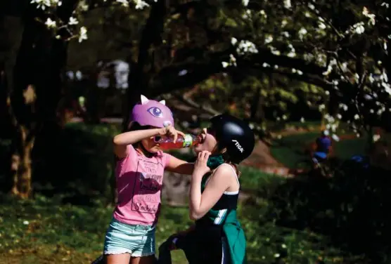  ?? FOTO: STIG B. HANSEN ?? Åtte år gamle Liana Sezemova og ni år gamle Olina Llanos deler en Fanta Exotic i Botanisk Hage under et magnoliatr­e som nå står i full blomst.