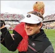  ?? CURTIS COMPTON / CCOMPTON@AJC.COM ?? Georgia coach Kirby Smart gives 5-year-old son Andrew a victory ride after the Bulldogs beat Georgia Tech to cap an 11-1 regular season.
