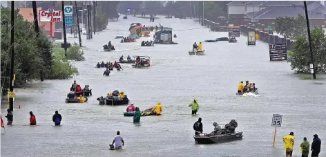  ?? FOTO: DPA ?? Mit Booten versuchen Einwohner von Houston, Texas, auf einer überflutet­en Straße voranzukom­men und in Autos Eingeschlo­ssenen zu helfen.