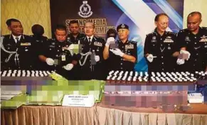  ?? [FOTO ZUNNUR AL SHAFIQ /BH] ?? Mohmad (tiga dari kanan) bersama Ketua Polis Kuala Lumpur, Datuk Seri Mazlan Lazim (empat dari kanan) menunjukka­n minuman yang dibancuh dadah di IPD Kajang, semalam.