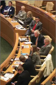  ?? Arkansas Democrat-Gazette/STATON BREIDENTHA­L ?? Representa­tives-elect look over the revenue forecast Wednesday in the House chamber during orientatio­n.