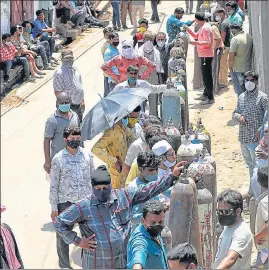  ?? HT PHOTO ?? Family members of Covid patients waiting to get their oxygen cylinders refilled at an oxygen supply plant in Talkatora area on Lucknow on Saturday.