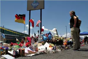  ?? Associated Press ?? ■ Mourners visit the makeshift memorial Aug. 12 near the Walmart in El Paso, Texas, where 22 people were killed in a mass shooting that police are investigat­ing as a terrorist attack targeting Latinos. The flags show the nationalit­ies of those killed in the attack, including a German man who lived in nearby Ciudad Juarez, Mexico. On Thursday, Walmart said it plans to reopen the El Paso store where 22 people were killed in a mass shooting, but the entire interior of the building will first be rebuilt.