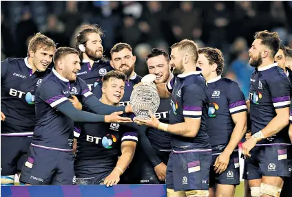  ??  ?? Glass act: Scotland captain John Barclay passes the Hopetoun Cup to Finn Russell after the crushing victory over Australia