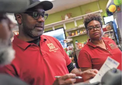  ?? ANTRANIK TAVITIAN/THE REPUBLIC ?? Gayle Reid, at right, looks over at an order that Curtis Reid and Shernie Gayle are discussing at Topnotch Island Flavor Kitchen in Phoenix on Feb. 4.