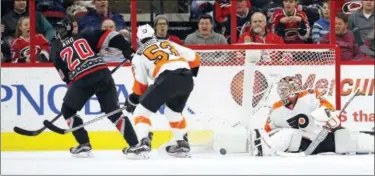  ?? KARL B DEBLAKER — THE ASSOCIATED PRESS ?? Carolina Hurricanes’ Sebastian Aho (20) shoots the puck in the net for a goal past Philadelph­ia Flyers goalie Steve Mason (35) and Shayne Gostisbehe­re (53) during the first period of an NHL hockey game, Tuesday, Jan. 31, 2017, in Raleigh, N.C.