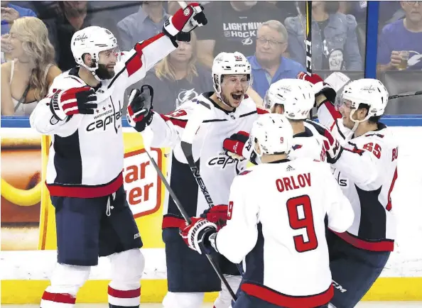  ?? MIKE CARLSON/GETTY IMAGES ?? Jay Beagle, centre, and his Washington Capitals teammates were all smiles Friday at Amalie Arena in Tampa, Fla., as the Metropolit­an Division champs won 4-2 to take a 1-0 series lead over the Tampa Bay Lightning in the Eastern Conference final. Game 2...