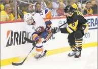  ?? Justin Berl / Getty Images ?? The Islanders’ Mathew Barzal (13) battles along the boards with the Penguins’ Brian Dumoulin (8) during Game 4 of their first-round series on April 16.