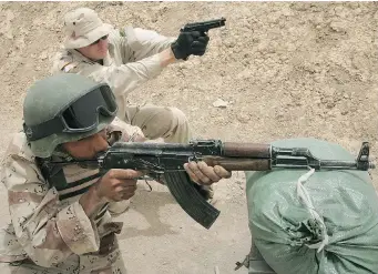  ?? GETTY IMAGES FILES ?? A U.S. special forces soldier fires his pistol alongside an Iraqi recruit, with an assault rifle, during an intense combat training course in Iraq in 2007. Up to 300 U.S. special forces are about to be deployed in Iraq again.