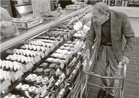  ?? Staff file photo ?? Sigmund Jucker, one of the founders of Three Brothers Bakery, looks over the display case at a then-newly opened location in February 2014 onWashingt­on Avenue. The brothers are credited with bringing bagels to Houston.