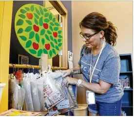  ?? TY GREENLEES / STAFF ?? Kinder Elementary School librarian Michelle Crespo sorts through books with audio packages as she prepares for the opening of the school year this coming week in Miamisburg.