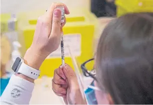  ?? ANDREW VAUGHAN THE CANADIAN PRESS ?? Allison Miley, a registered nurse in Halifax, prepares a COVID-19 vaccine on Monday. Family doctors in Ontario say they’re still in the dark about how the vaccine rollout will happen here.