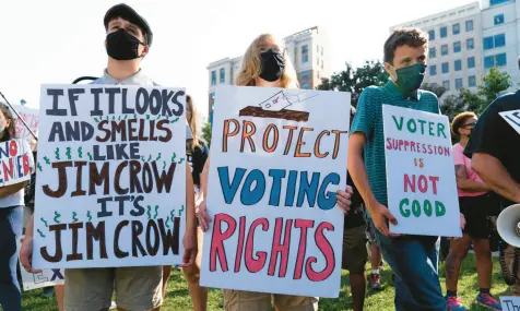  ?? JOSE LUIS MAGANA/AP ?? Demonstrat­ors in Washington hold signs during an Aug. 28, 2021 march for voting rights, marking the 58th anniversar­y of the March on Washington. Hundreds of thousands of voting rights advocates rallied across the country Saturday to call for sweeping protection­s against a further erosion of the Voting Rights Act of 1965.