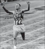  ?? Associated Press ?? In this Oct. 14, 1964, photo, U.S. Marine Lt. Billy Mills pulls off a stunning upset by winning the 10,000-meter Olympic race in Tokyo. Mills set an Olympic record 0f 28:24:4, and was the only American ever to win the event.