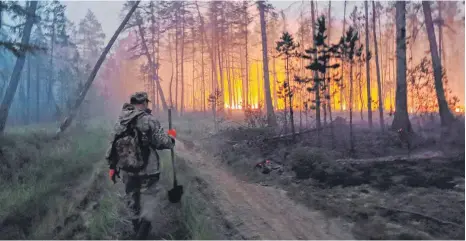  ?? FOTO: IVAN NIKIFOROV/AP/DPA ?? Freiwillig­e bekämpfen einen Waldbrand in Jakutien.