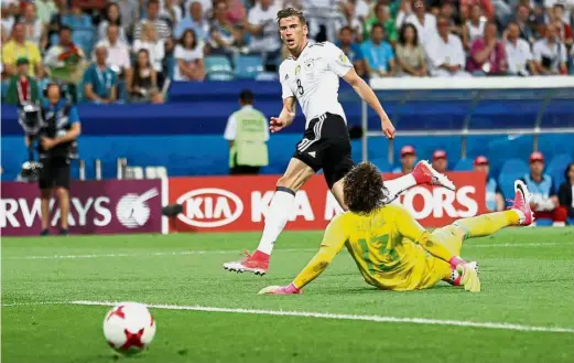  ??  ?? Neat finish: Germany’s Leon Goretzka scores the second goal against Mexico in the Confederat­ions Cup semi-final at the Fisht Stadium in Sochi, Russia, on Thursday. Below: Goretzka (right) is hugged by Benjamin Henrichs.