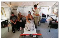  ?? AP/GERALD HERBERT ?? Corey Shuman and Amy Cross sit with Cross’ daughter, Aleeah Racette, as she receives medical treatment Thursday in a disaster medical assistance tent outside a hospital in Mexico Beach, Fla., in the aftermath of Hurricane Michael.