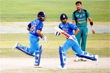  ?? — AFP photo ?? Rohit Sharma (left) and his teammate Shikhar Dhawan (centre) run between the wickets during the one day internatio­nal (ODI) Asia Cup cricket match between Pakistan and India at the Dubai Internatio­nal Cricket Stadium in Dubai.