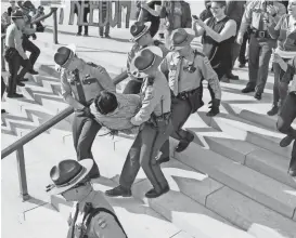  ?? MARK HUMPHREY / FILE / AP ?? A protester is carried away from the state Capitol building on Jan. 20 in Nashville. Protests around the state Capitol in Nashville have some Republican­s calling for a crackdown on demonstrat­ors and for resurrecti­ng more stringent security requiremen­ts...