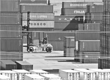  ??  ?? Shipping containers from China and other nations are unloaded at the Long Beach Port in Los Angeles, California. — AFP photo