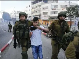  ?? THE ASSOCIATED PRESS ?? Israeli soldiers detain a Palestinia­n boy during clashes at a protest against U.S. President Donald Trump’s decision to recognize Jerusalem as the capital of Israel in the West Bank city of Hebron, Friday, Dec. 15, 2017.