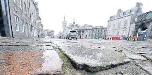  ?? Photograph by Jim Irvine ?? CRACKS: Business owners in Aberdeen’s Castlegate say customers complain about loose flagstones and setts.