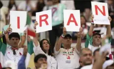  ?? Associated Press ?? Iranian soccer fans hold up signs prior to the World Cup soccer match between England and Iran on Monday at the Khalifa Internatio­nal Stadium in in Doha, Qatar. More World Cup coverage in Sports, Page 23 C-1.