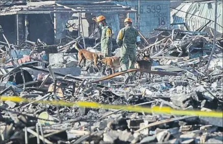  ?? ALEX CRUZ / EFE ?? Soldados mexicanos recorren la zona afectada por la explosión con perros especializ­ados en rescates