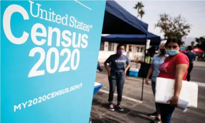  ??  ?? A woman talks with volunteers to fill out the form for the 2020 US census in Sylmar, California, on 17 August 2020. The state lost a congressio­nal seat after the census. Photograph: Étienne Laurent/EPA