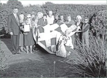  ?? 01_B42twe04 ?? Mrs Ruby Middleton receives her long service certificat­e from Mr Kevin Carty while other members of the Arran branch of the Arthritis and Rheumatism Council display the beautiful quilt they raffled for funds.