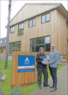  ??  ?? VisitScotl­and’s regional leadership director Chris Taylor paid a visit to Glen Nevis Youth Hostel last week to present the award to Lochaber group manager Caroline Knox.