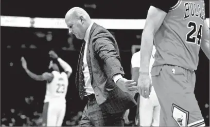  ?? CHRIS SWEDA/CHICAGO TRIBUNE ?? Jim Boylen walks onto the court for a timeout as LeBron James celebrates in the background during a Nov. 5 game.