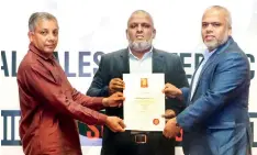  ??  ?? Mawbima Lanka Foundation Board Director Dr. Sumith Wanniarach­i presents certificat­ion to Ebony Holdings Chairman Rasmi Raheem and Managing Director Raseen Raheem