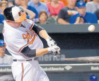  ?? KARL MERTON FERRON/BALTIMORE SUN ?? Mark Trumbo breaks his bat in popping out to second base in the fourth inning. The Orioles allowed three runs in the first and scored just one run until the ninth in losing to Toronto and falling four games behind the Blue Jays in the AL East and into...