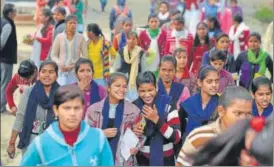  ??  ?? ▪ (From left) Girls coming out of BKT Inter College in Lucknow after taking the exam; an official monitoring exam centre at BKT Inter College through CCTV cam and examinees seated near constructi­on material dumped outside a college in Itaunja.