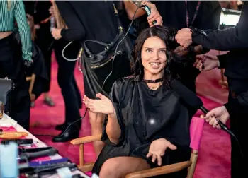  ??  ?? Adriana Lima appears backstage during hair and makeup at the show