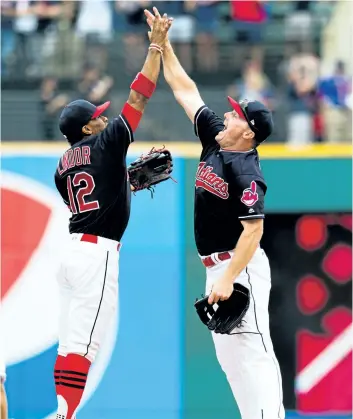  ?? JASON MILLER/GETTY IMAGES ?? Cleveland teammates Francisco Lindor, left, and Jay Bruce celebrate after defeating the Tigers on Wednesday to win their 21st straight game.