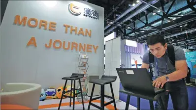  ?? JASON LEE / REUTERS ?? An employee of Didi Chuxing setting up the company’s stand at a mobile internet conference in Beijing.