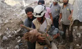  ??  ?? A member of the White Helmets, also known as the Syrian civil defence, holds a child pulled from the rubble following an airstrike in Aleppo in 2016. Photograph: Ameer Alhalbi/ AFP/Getty Images