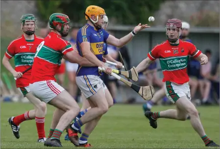  ??  ?? Kilshannig’s Kevin Flynn lays off a handpass as he gets swarmed by Doneraile players during Saturday’s Junior A Hurling Championsh­ip clash in Buttevant. Photo by Eric Barry