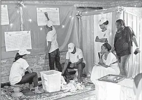  ?? AP/JEROME DELAY ?? Poll workers at a station in Rwanda’s capital, Kigali, start counting votes in Friday’s presidenti­al election.