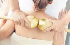  ??  ?? BELOW
Rolling the golden wood massager to relieve muscle tension.