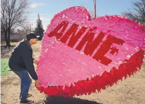  ?? JIM THOMPSON/JOURNAL ?? Lonnie Anderson helps prepare a huge candy heart piñata to go aloft via a crane. The piñata was Anderson’s grand gesture for Valentine’s Day this year.