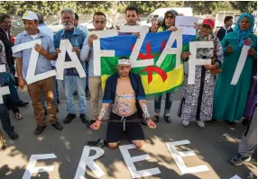  ??  ?? Supporters of Morocco’s Al-Hirak Al-Shaabi movement hold placards and shout slogans calling for the release of the movement’s leader Nasser Zefzafi outside the Casablanca Court of Appeal during his trial recently. (AFP)