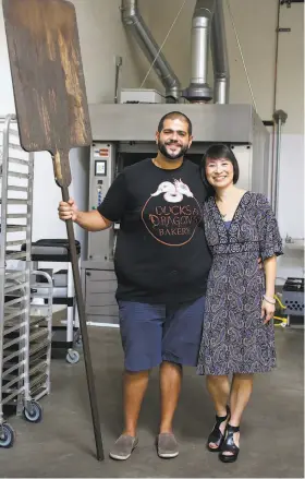  ??  ?? Clockwise from top: Ducks & Dragon owner Mina Makram takes out some of his signature gluten-free bread from the oven; some of the finished products; Makram and partner Kim Sullivan pose in their San Carlos kitchen.