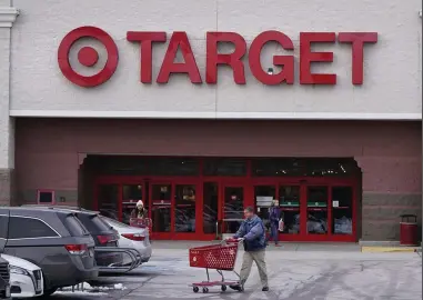  ?? (AP/Charles Krupa) ?? A shopper wheels his shopping cart through the parking lot at a Target store in Salem, N.H., on Monday.