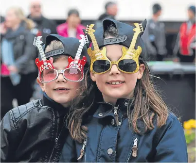  ?? Pictures: Kim Cessford. ?? Young fans Callum and Bethany Crawford show their rock credential­s in Kirriemuir’s Town Square as BonFest gets into full swing.