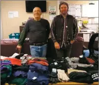  ?? Courtesy photo ?? From left: Taos Men’s Shelter client Peter Compton and program manager Ethan Naszady lay out donated hats, gloves and other items for men who will need them during the increasing­ly cold weather.